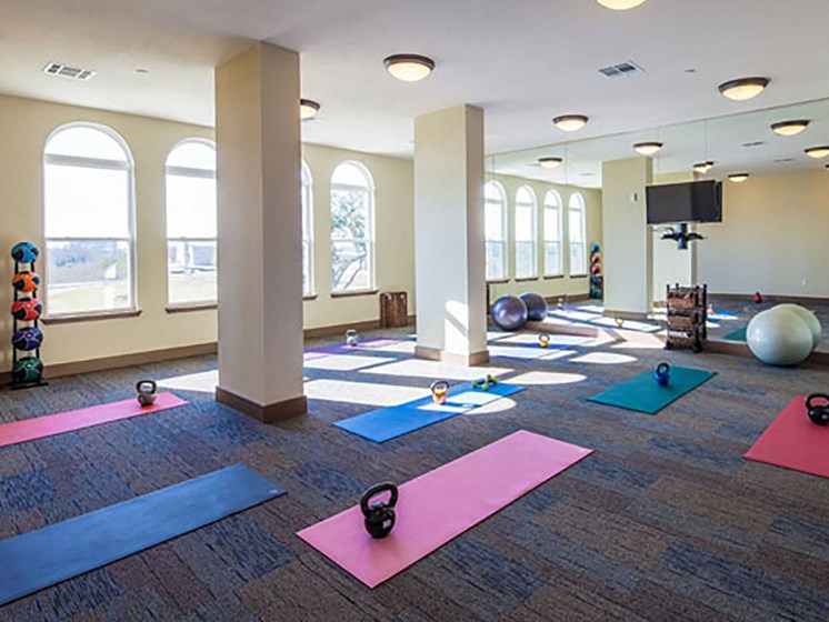 a yoga studio with yoga mats and dumbbells on the floor